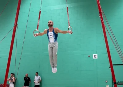 Coach Stefan Kolimechkov executing the Iron Cross during the Men's London Open gymnastics competition in the UK.