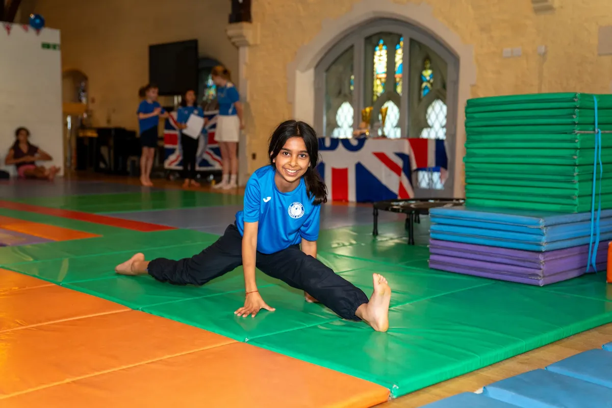 Smiling child practising gymnastics at Kensington & Chelsea Gymnastics.