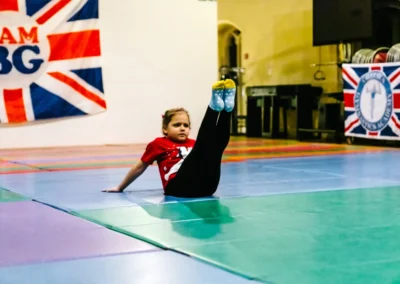 Girl performs a v-sit hold during Chelsea Gymnastics Academy Christmas event in Kensington.