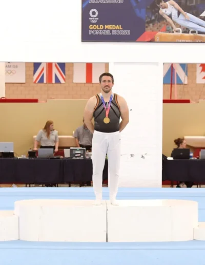 Stefan Kolimechkov standing on the podium alongside other medalists at the 2023 British Gymnastics Adult Championships.