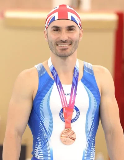 Close-up of Coach Stefan Kolimechkov wearing his bronze medal at the 2023 British Gymnastics Adult Championships.