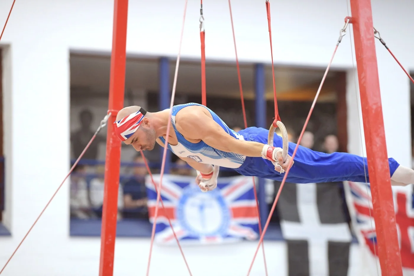 Coach Stefan Kolimechkov performing a Maltese cross on rings at the 2023 British Gymnastics Adult Championships in Lilleshall.