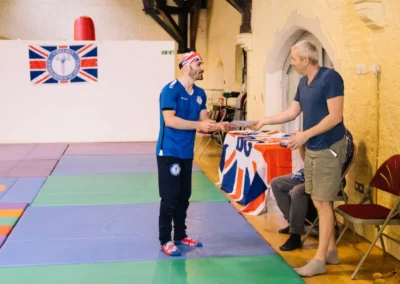 Coach Stefan presenting a certificate of appreciation to Adam from The Kensington Studio for his support to Chelsea Gymnastics Academy.