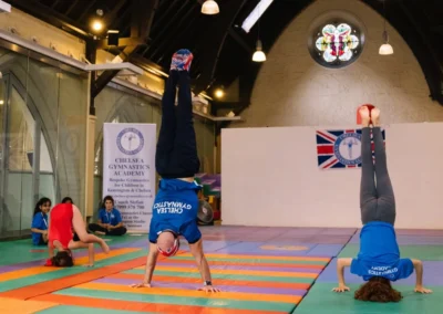 Coach Stefan performing a handstand alongside his gymnasts during the Annual Performance 2023 at KCGA in Kensington.