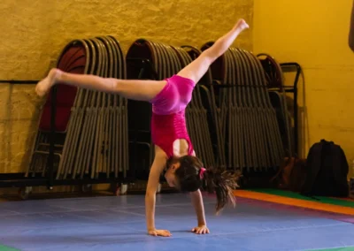 Young gymnast performing a cartwheel during the 2023 Annual Performance at Kensington & Chelsea Gymnastics Academy.