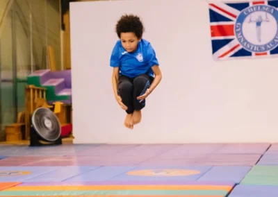 Young boy performing a tuck jump during the Annual Performance 2023 at Chelsea Gymnastics Academy in Kensington.