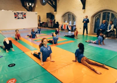 Group of children practising flexibility during KCGA Easter gymnastics event in Kensington London W8.