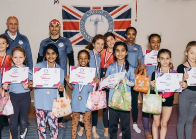 Group of KCGA gymnasts holding certificates and medals at Easter gymnastics awards in Kensington London W8.