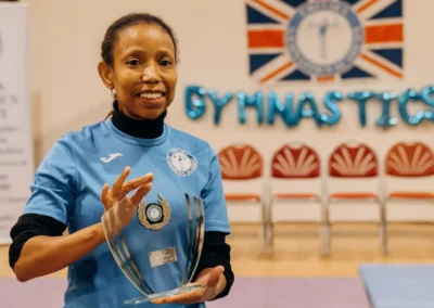Welfare Officer holding an award during the Christmas 2023 children’s gymnastics event at Chelsea Gymnastics Academy in Kensington, London.