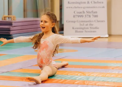Young gymnast performing a split during the KCGA Christmas 2023 gymnastics event in Kensington London.
