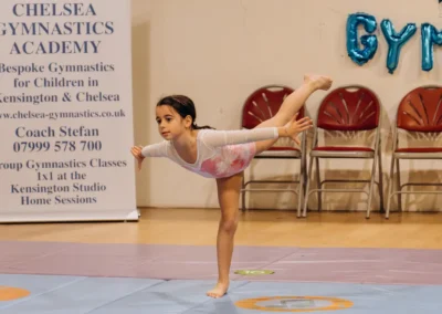 Young gymnast performing an arabesque balance pose at the KCGA Christmas 2023 event in Kensington London.