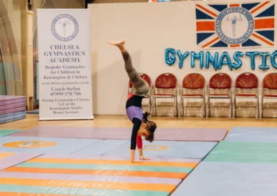 Young gymnast demonstrating a handstand during the KCGA Christmas 2023 showcase in Kensington London.