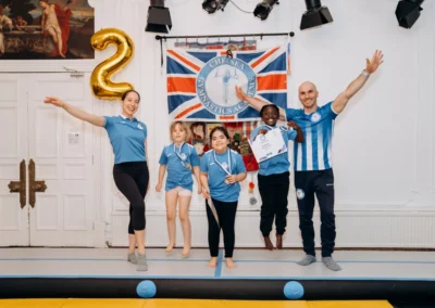 Children and coaches celebrating during gymnastics classes in Knightsbridge SW1X