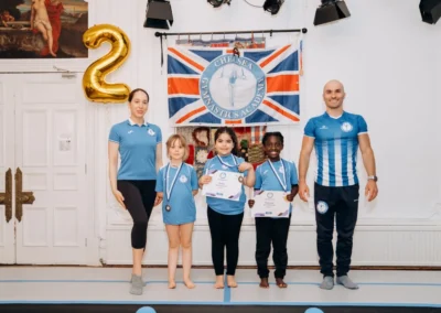 Children and coaches celebrating during gymnastics classes in Knightsbridge SW1X