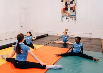 Children practising flexibility during gymnastics classes in Knightsbridge SW1X at Kensington & Chelsea Gymnastics Academy