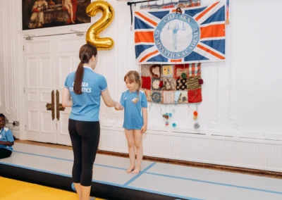 Elite National level Coach supporting a child during gymnastics classes for children in Knightsbridge London