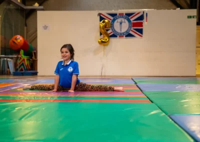 Child performing box split during gymnastics performance in Kensington London