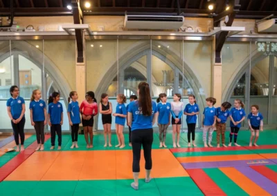 Children lined up with National Level coach during gymnastics performance in Kensington London