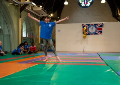 Child performing expressive floor movement at gymnastics performance in Kensington
