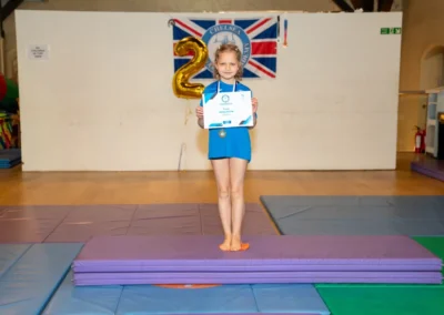 Child holding gymnastics certificate at KCGA Annual Performance 2024 in Kensington London