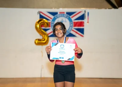 Smiling child holding gymnastics certificate at Annual Performance in Kensington London