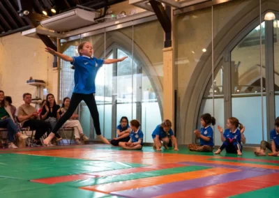 Child performing jump during gymnastics performance in Kensington London