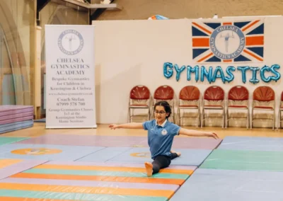 Young gymnast performing a floor split during the 2023 Christmas gymnastics event at Kensington & Chelsea Gymnastics Academy.