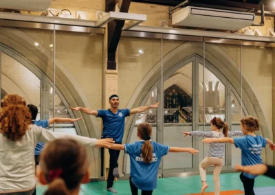 Coach Stefan Kolimechkov guiding children during the KCGA Christmas 2023 gymnastics performance in Kensington London.