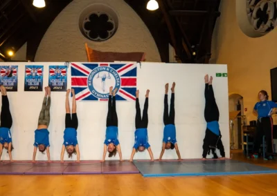Easter 2025 children’s gymnastics class in Kensington & Chelsea – gymnasts practise handstands together under KCGA coaching.