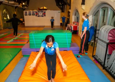 Child practising safe vault landing techniques during an Easter 2025 gymnastics class in London.