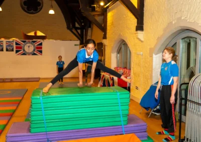 Child practising straddle over vault technique during Easter 2025 gymnastics session at Kensington & Chelsea Gymnastics Academy