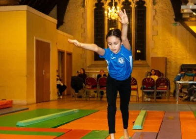 Child practising balance beam skills during Easter 2025 gymnastics session in Kensington London