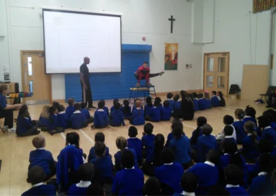 A gymnastics coach performing gymnastics in front of school children to inspire more students to join his after school club