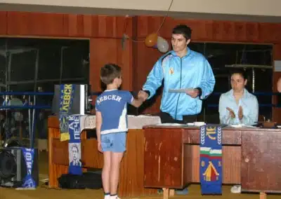 Coach Stefan Kolimechkov awarding a certificate to a young gymnast during a gymnastics show in Bulgaria, 2011