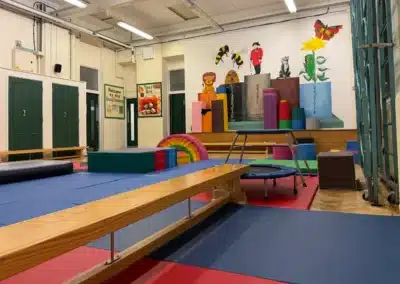 Spacious indoor hall at Park Walk School in Chelsea set up for children’s gymnastics classes with mats and balance equipment