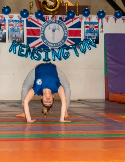 Adult female gymnast performing bridge pose during KCGA Annual Performance in Kensington London