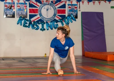 Adult female gymnast performing a front split on floor mats at KCGA Annual Performance 2025 in Kensington London