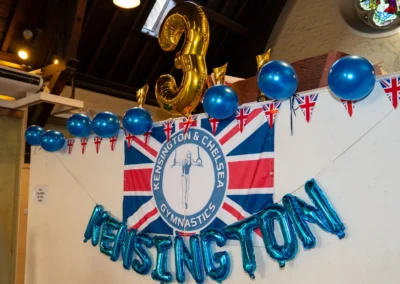 Kensington & Chelsea Gymnastics banner with 3-year anniversary decorations at Annual Performance 2025 in London