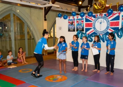 Gymnastics coaches presenting certificates to children in London