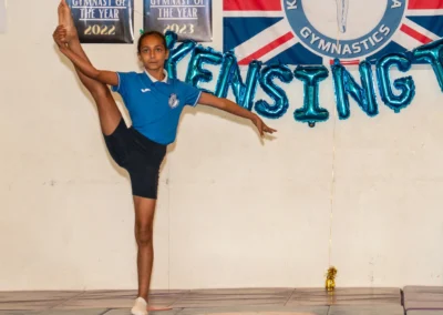 Young gymnast holding high leg extension pose at KCGA 2025 Annual Performance in Kensington London
