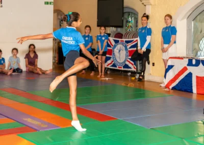 Young gymnast performing balance turn during KCGA Annual Performance Kensington London