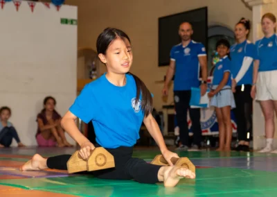 Young gymnast performing front split with mini bars at KCGA Annual Performance Kensington