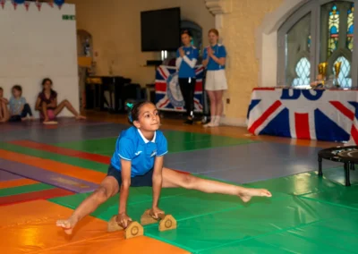 Young gymnast performing straddle l-sit during annual gymnastics performance in London