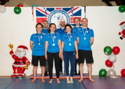 Group of adult gymnasts with medals during Chelsea Gymnastics Christmas event in London.