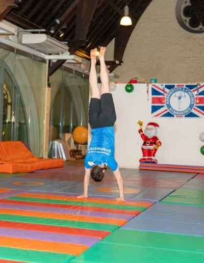 Adult gymnast performing a controlled handstand during an adult gymnastics class in Kensington London W8.