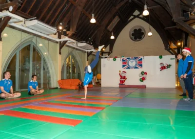 Adult gymnast performing a one-handed cartwheel during an adult gymnastics class in Kensington London W8.