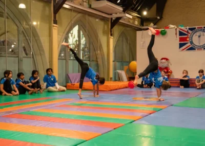 Children performing cartwheels during the KCGA Christmas 2024 event at Kensington Gymnastics Club