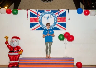 Young gymnast proudly holding a trophy during the Christmas 2024 event at Kensington Gymnastics Club.