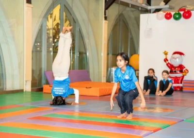 Child performing a headstand during the KCGA Christmas 2024 gymnastics event at Kensington Gymnastics Club