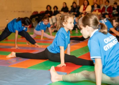 Children practising flexibility and splits during the KCGA Christmas 2024 gymnastics event at Kensington Gymnastics Club